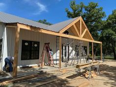 two men are working on the roof of a house that is being built with wood