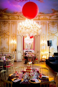 a fancy dining room with chandelier, table and chairs set for an event