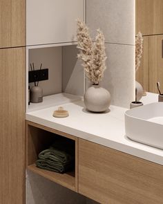 a white sink sitting under a mirror next to a wooden cabinet and wall mounted faucet