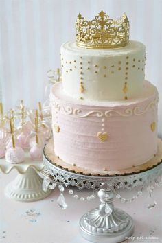 there is a three layer cake with gold decorations on the top and bottom tiers