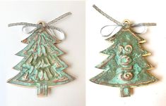 two christmas tree ornaments are hanging on the wall, one is green and the other is gold