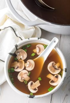 a bowl of soup with mushrooms and green onions