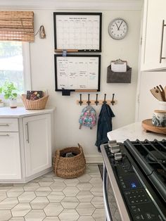 a kitchen with a stove, oven and wall calendars on the wall above it