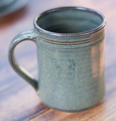 a coffee cup sitting on top of a wooden table