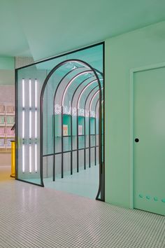 an empty room with green walls and white tile flooring is seen through the glass doors