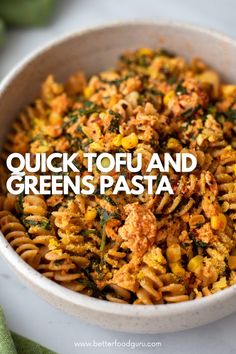 a white bowl filled with pasta covered in cheese and greens next to a green napkin