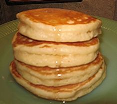 a stack of pancakes sitting on top of a green plate