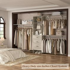 a bedroom with a bed, dresser and closet full of clothes on hangers next to a window