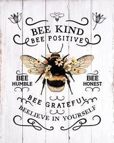 a bee is sitting on top of a wooden sign with the words be kind of positive