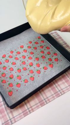 someone is decorating a tray with strawberries on it