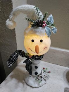 a snowman with a hat and scarf on top of a counter