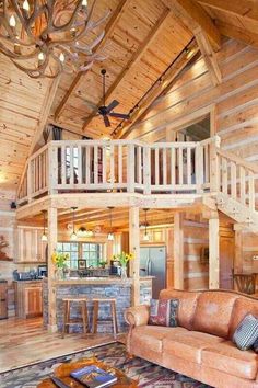 a living room filled with furniture next to a wooden ceiling and staircase leading up to a loft