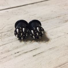 pair of black studded earrings on wooden surface