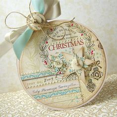 a close up of a christmas ornament on a table with ribbon and bow