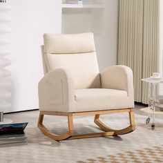 a white rocking chair sitting in a living room