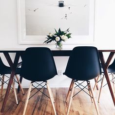 four chairs sitting at a table in front of a painting