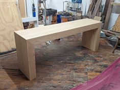 a wooden bench sitting on top of a hard wood floor next to plywood boards