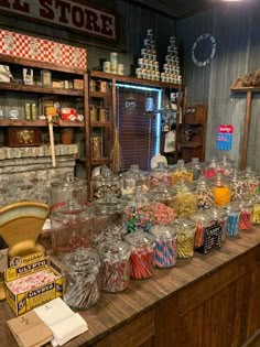 a store filled with lots of different types of candy and candies on top of a wooden counter