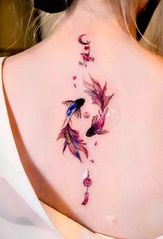 the back of a woman's neck is decorated with colorful fish