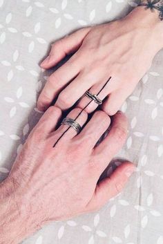 two hands holding each other with rings on their fingers