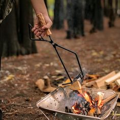 a person holding a stick over an open fire