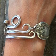 a person's arm with two metal bracelets on top of it and an object in the middle