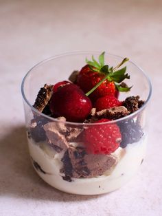 a dessert in a glass bowl with strawberries on top