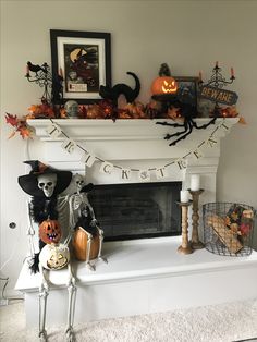 a mantle decorated with halloween decorations and pumpkins