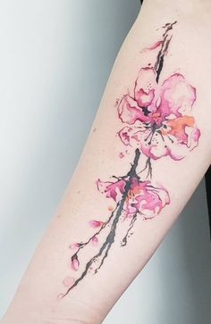 a woman's arm with pink flowers on the left side of her body and watercolor