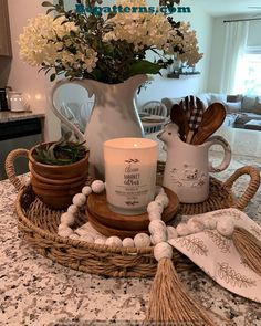 a candle and some flowers in a basket on a counter top with kitchen utensils