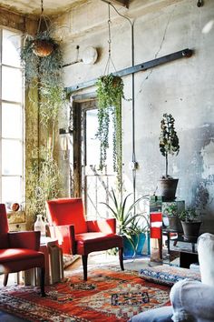 a living room filled with lots of furniture and plants