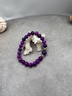 Elevate your style and spirit with this stunning Sugilite and Amethyst gemstone bracelet. Handcrafted with love and care in Port Saint Lucie, Florida, this bracelet features the soothing energies of Sugilite paired with the calming properties of Amethyst. Let this bracelet serve as a reminder of your beachside adventures, with two silver spacers adding a touch of elegance. Whether you're strolling along the shore or attending a special event, this stretch bracelet is the perfect accessory. Harne Purple Natural Stone Beaded Bracelets For Meditation, Purple Gemstone Beads Bracelets For Healing, Spiritual Amethyst Bracelets In Purple, Purple Natural Stones Beaded Bracelets For Meditation, Purple Beaded Bracelets With Natural Stones For Meditation, Purple Beaded Bracelets With Natural Stones For Healing, Purple Gemstone Beaded Bracelets For Healing, Purple Bracelets With 8mm Beads For Healing, Spiritual Amethyst Purple Bracelets