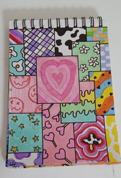 a colorful notebook covered in lots of different colored designs and shapes, with a heart drawn on the cover