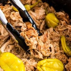 two tongs in a pot filled with shredded meat and peppers next to pickles