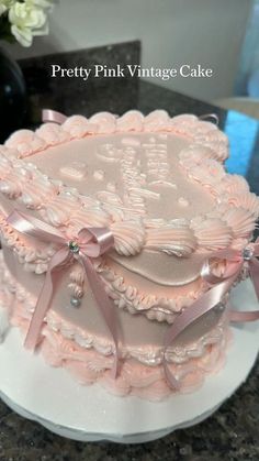 a pink cake decorated with hearts and bows