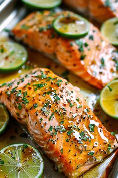 salmon with lemons, limes and seasoning on a baking sheet covered in foil