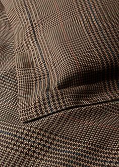 a close up view of a brown and black checkered bed sheet with pillow cases