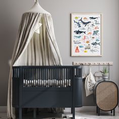 a baby's room with a crib, rocking chair and artwork