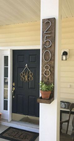 a black front door with a sign that says coco on it and a potted plant