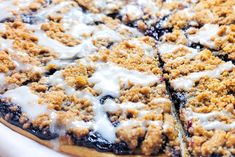 a blueberry crumb pie with white icing on it's crusts