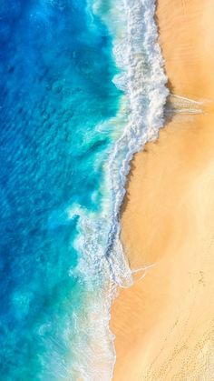 an aerial view of the ocean and sandy beach