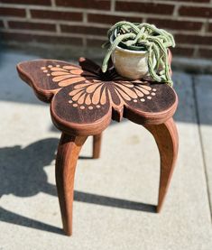 a small wooden table with a potted plant on it's top and legs