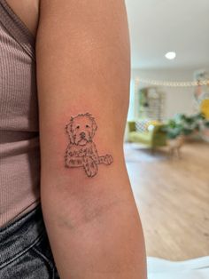 a woman's arm with a small tattoo of a teddy bear holding a baseball bat