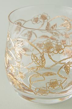 a clear glass with gold floral designs on it