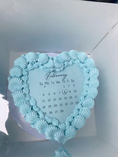 a blue heart shaped cake in a white box