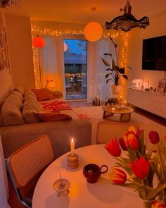 a living room filled with furniture and a flat screen tv mounted to the wall next to a window