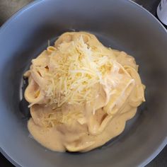 a bowl filled with pasta and cheese on top of a table