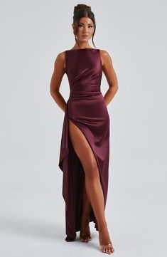 a woman wearing a purple dress with high slit