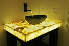 a sink that is sitting on top of a wooden table in a room with yellow walls