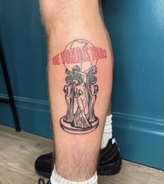 a man with a tattoo on his leg that says the world is yours and an image of a statue